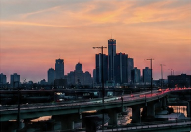 The Detroit skyline and elevated roads beneath an orange sunset