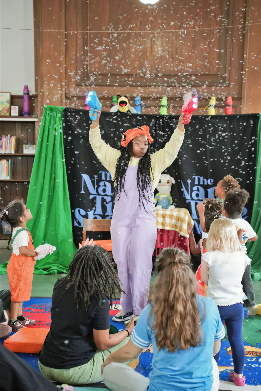 Sierra Boone filling the library with bubbles as children gather around