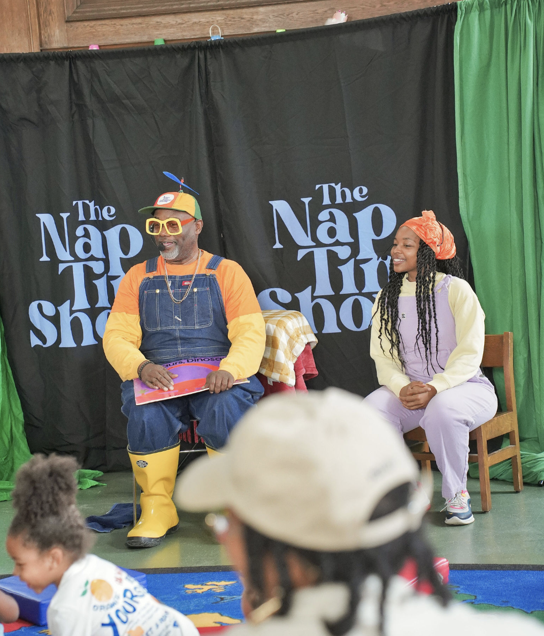 Mr. Boots and Sierra Boone seated in front of The Nap Time Show backdrop